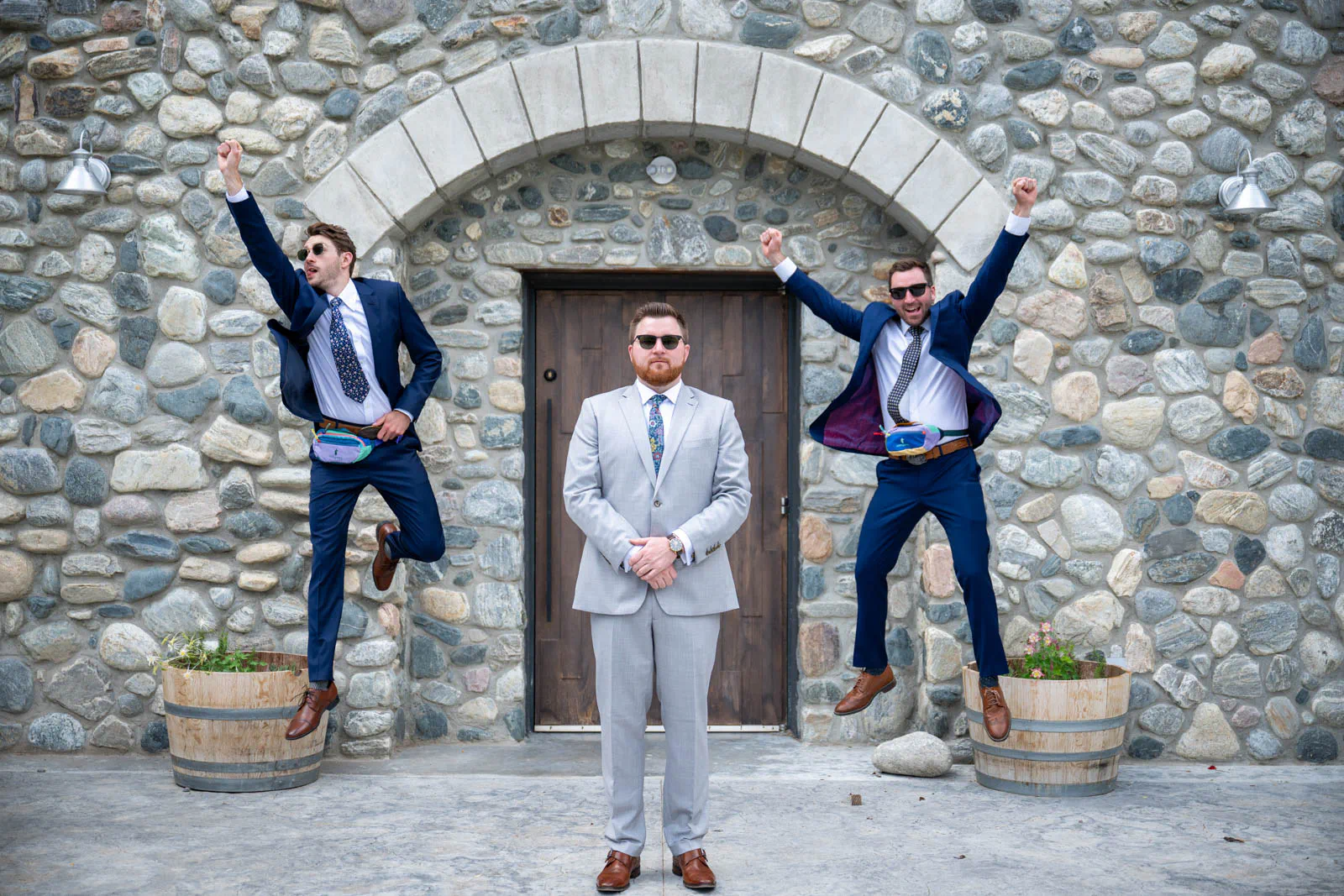 Groom and groomsmen jumping in air