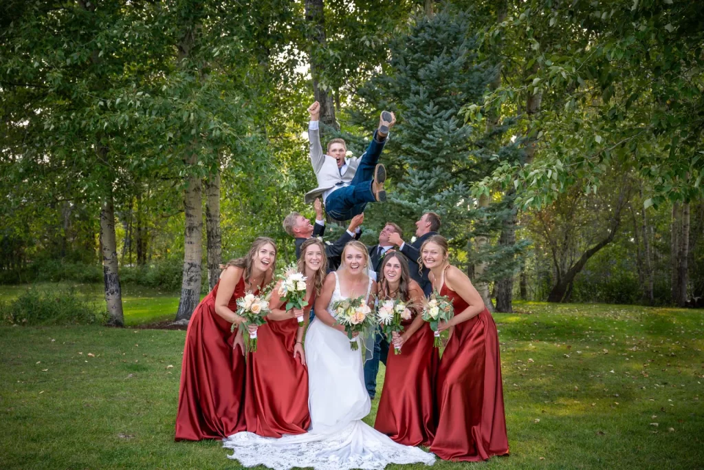 Groom thrown in the air wedding party portrait funny