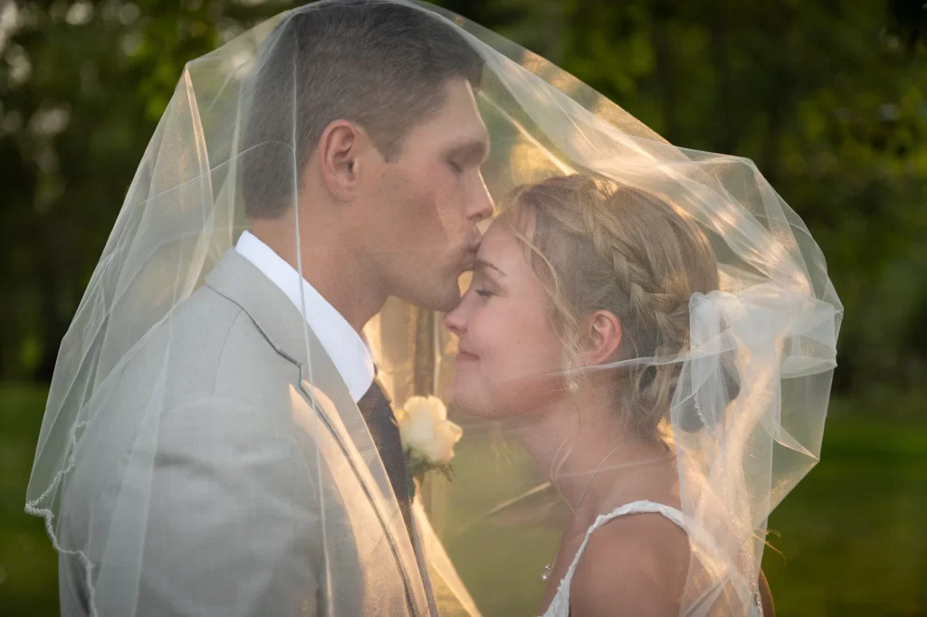 Groom kisses bride's forehead at Rocking TJ Ranch Bozeman Montana