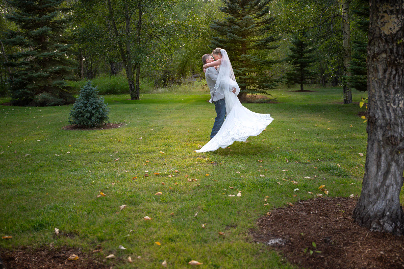 Groom swinging bride on lawn at Rocking TJ Ranch, Montana