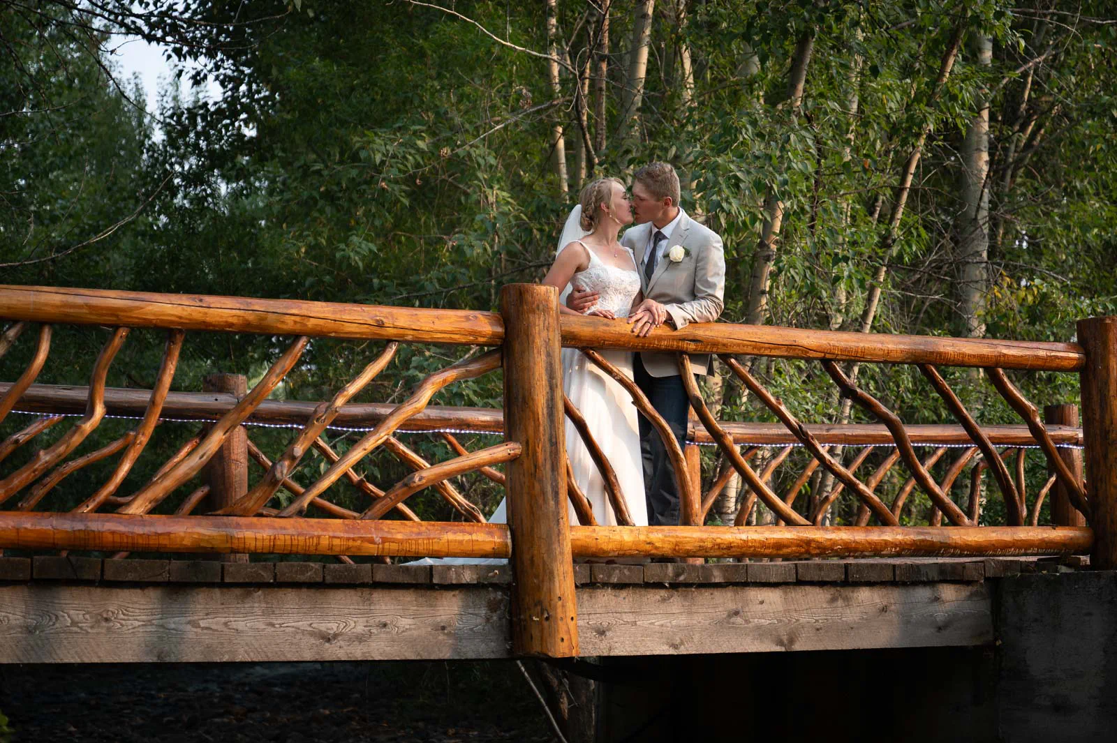 Couple kissing on bridge at Rocking TJ Ranch, Bozeman, Montana